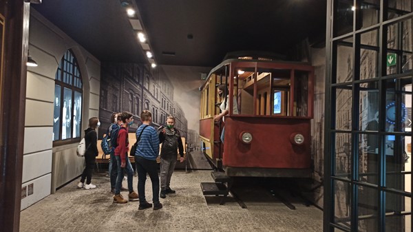 Uczniowie w Muzeum stoją przy zabytkowym tramwaju