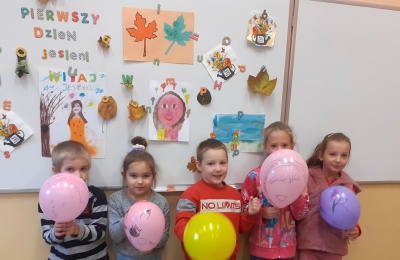 Dzieci z balonami na tle tablicy