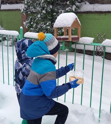 Zdjęcia z akcji - karmniki i pokarm, dzieci uczestniczące w akcji.